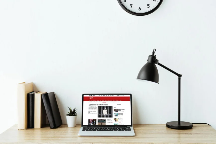 Laptop with BBC news website on screen on work desk at office mockup