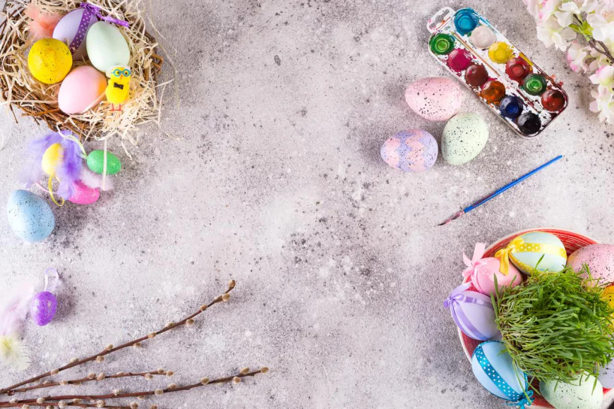 Easter eggs in a grass nest, homemade iced cookies, and paints for painting eggs and grass